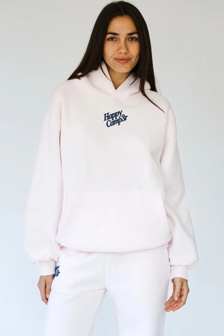 Woman wearing matching light pink sweatsuit with &
