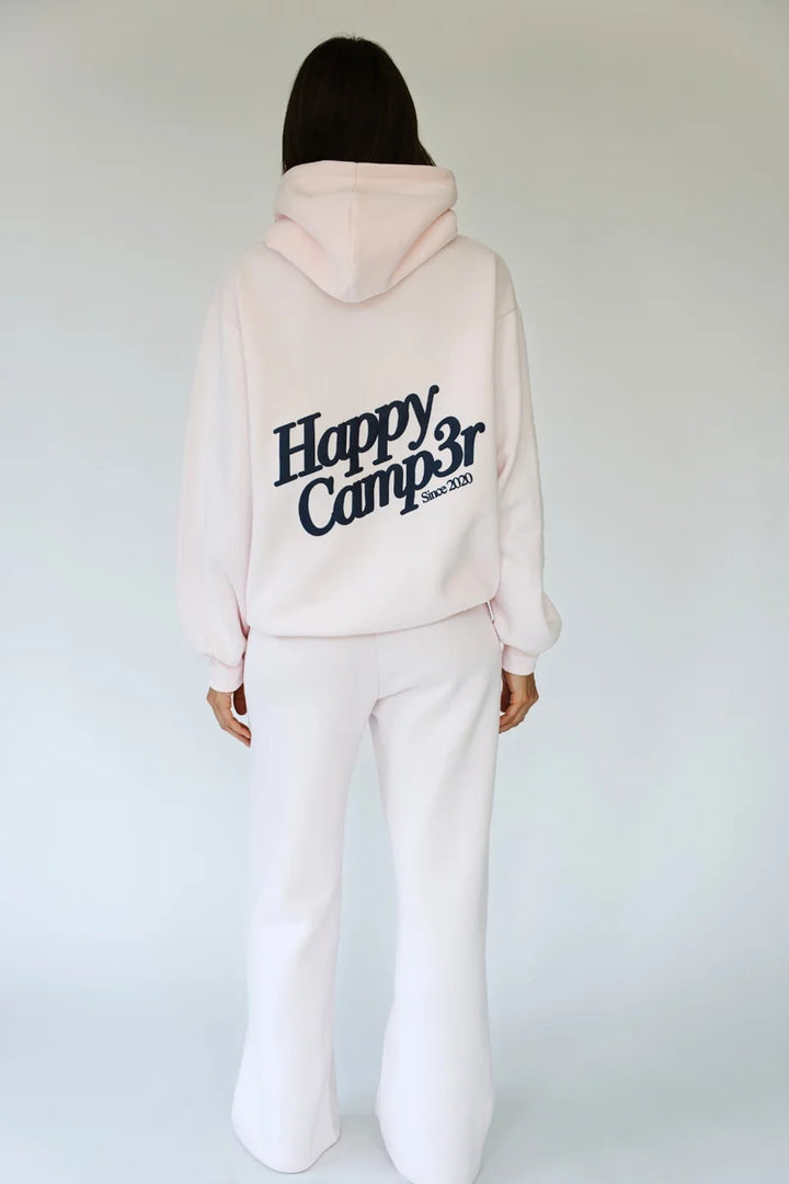 Woman wearing matching light pink sweatsuit with &