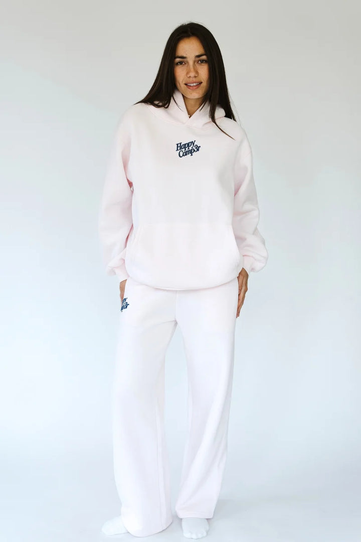 Woman wearing matching light pink sweatsuit with &