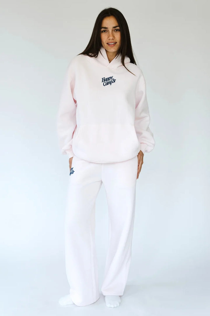 Woman wearing matching light pink sweatsuit on white background