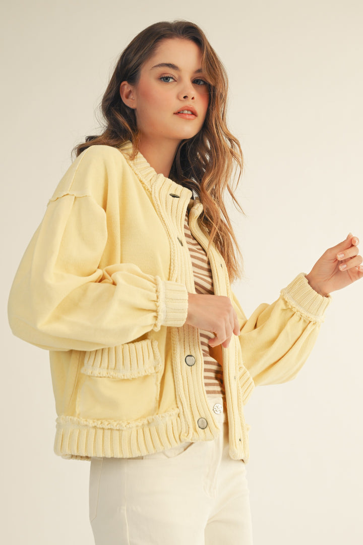 Woman wearing a light yellow jacket on a plain background