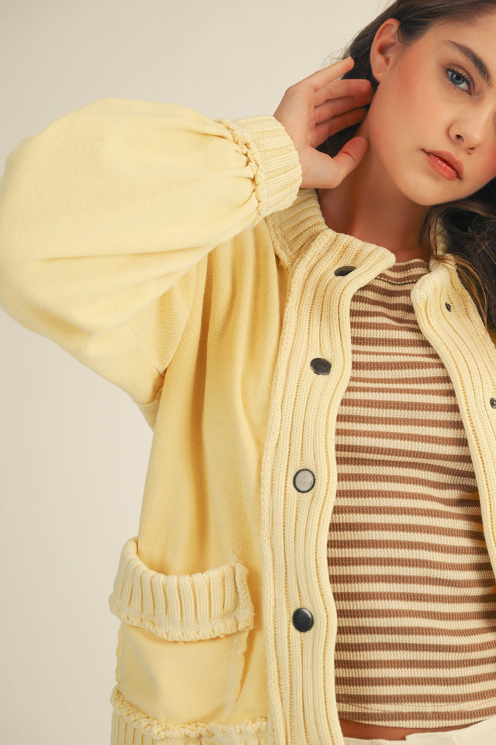 woman wearing yellow cardigan on plain background
