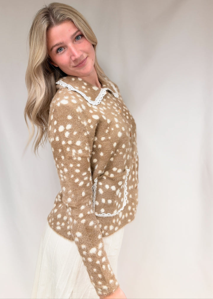 Woman shown from side view wearing fawn print fuzzy cardigan with lace detail on plain background