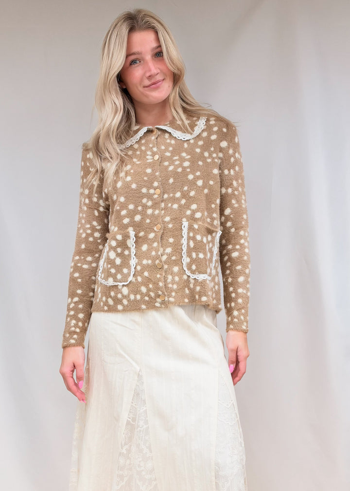 Woman wearing fawn print fuzzy cardigan with lace detail and lace detail maxi skirt on plain background