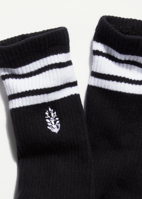 Pair of black and white stripe logo tube socks on plain background