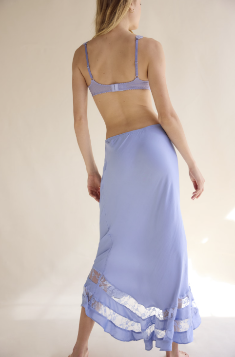 Woman wearing a light blue lace-trimmed nightgown against a plain background
