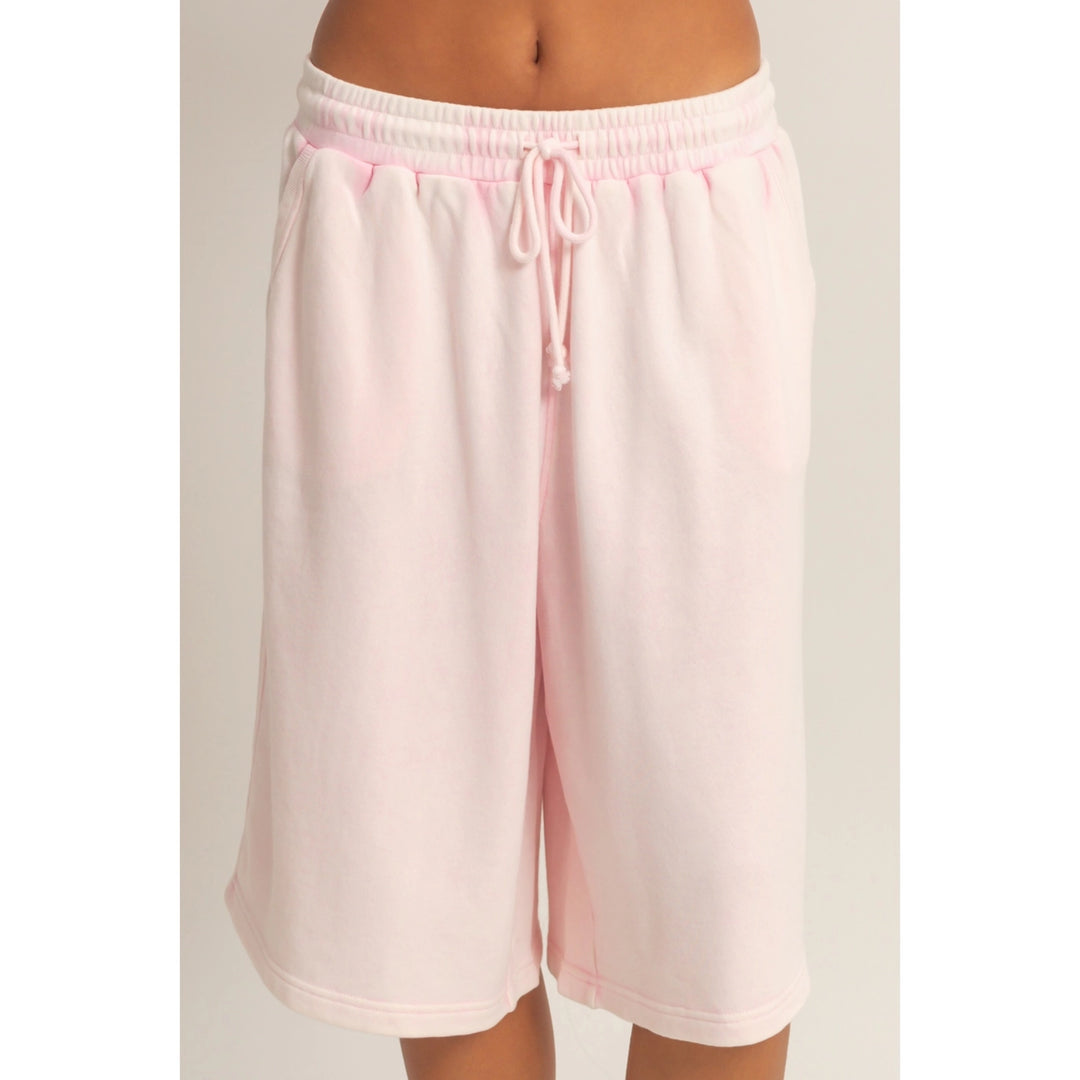 Pink shorts with a drawstring on a plain background