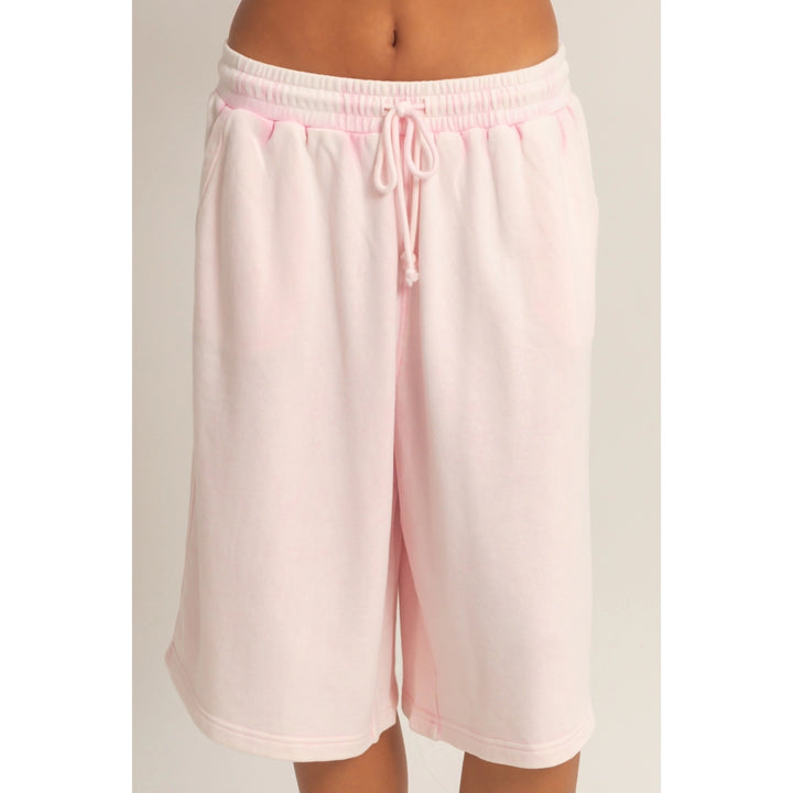 Pink shorts with a drawstring on a plain background