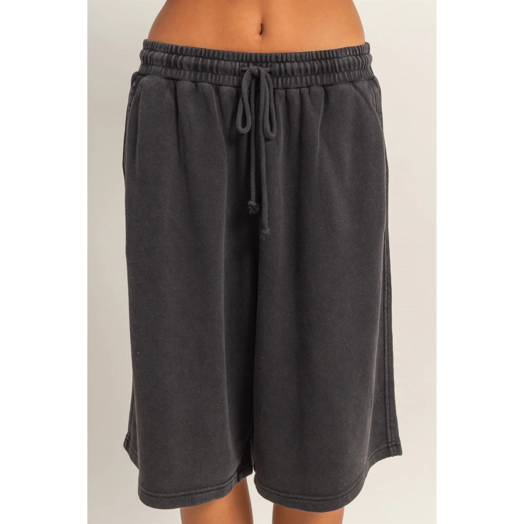 Dark gray shorts with a drawstring on a light beige background