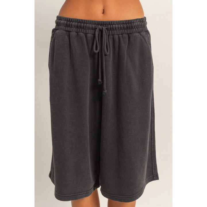 Dark gray shorts with a drawstring on a light beige background