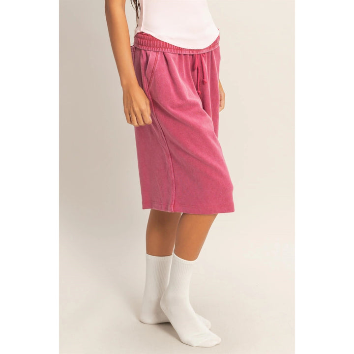 Person wearing a pink skirt and white socks on a plain background