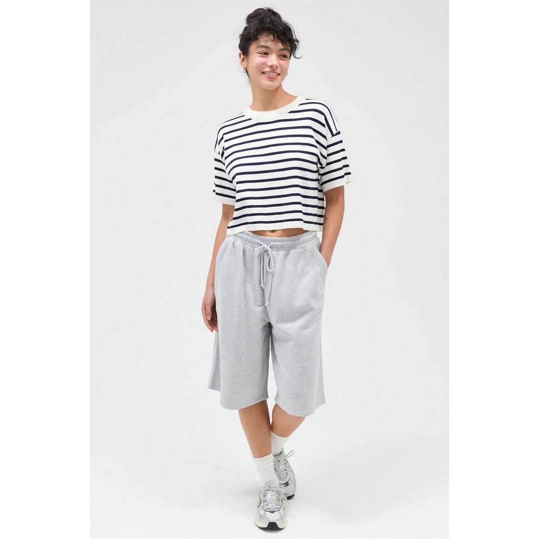 Person wearing a striped shirt and gray shorts on a white background