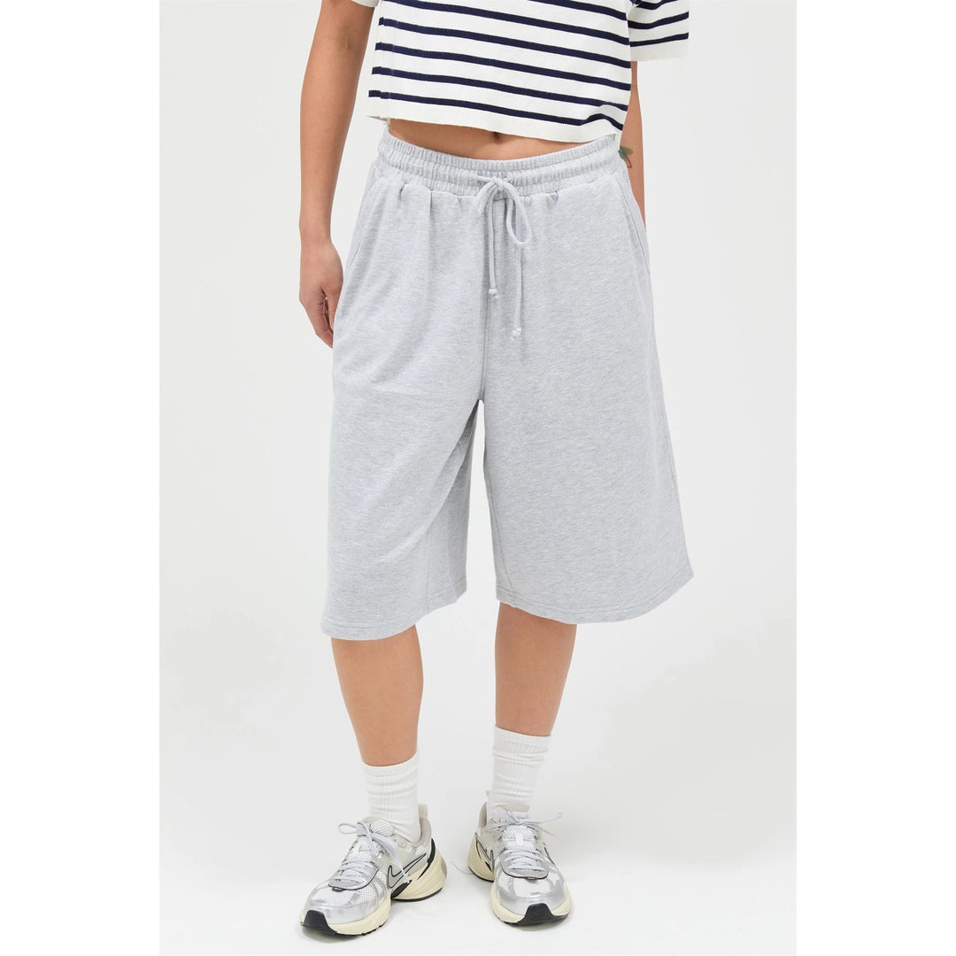 Person wearing gray sweatpants and a striped shirt on a white background