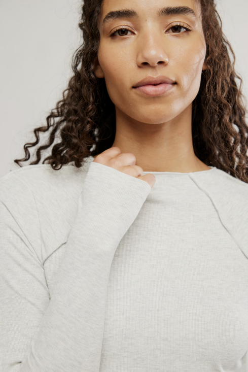 Woman wearing a light gray shirt against a plain background