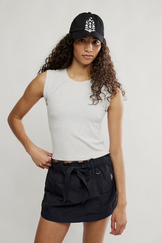 Woman wearing grey tee and black skirt on white background