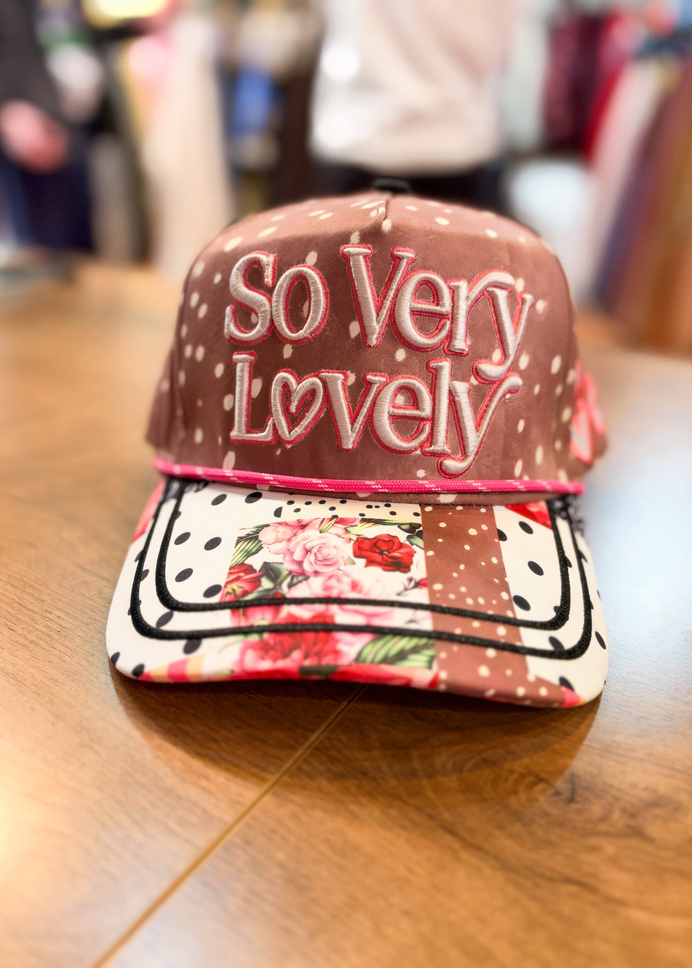 Brown polka dot trucker hat with 'SO VERY LOVELY' embroidered on front with patchwork bill