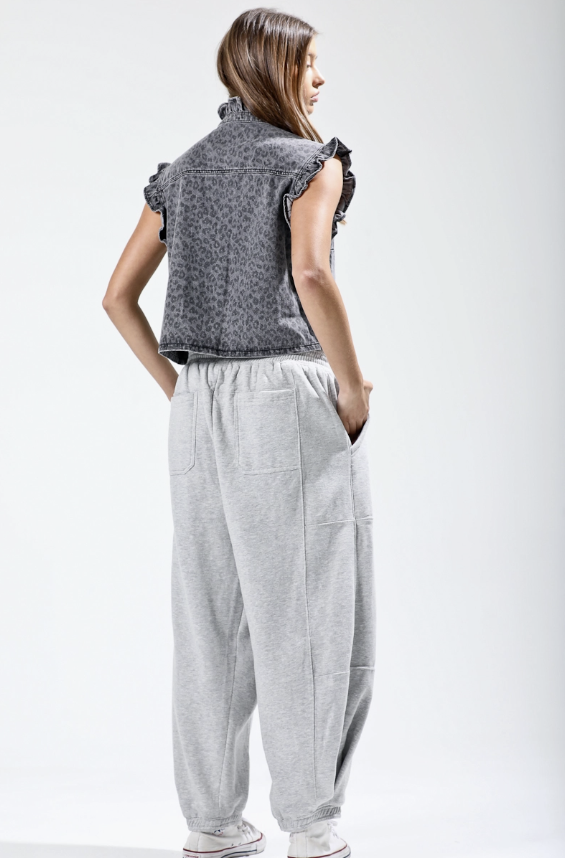 Woman wearing a gray sleeveless top and wide-leg pants on a white background