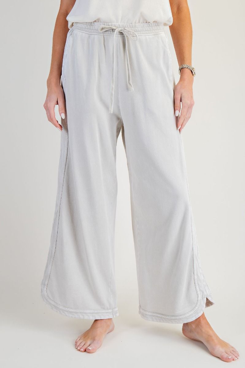 Light gray wide-leg pants worn by a person on a white background