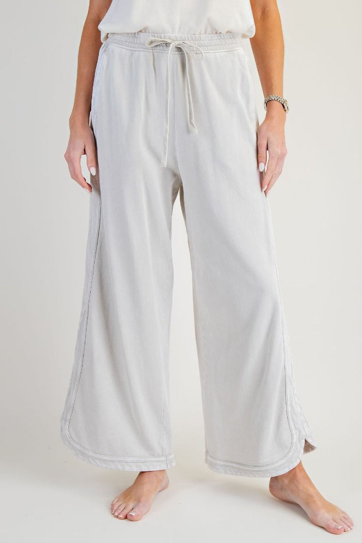 Light gray wide-leg pants worn by a person on a white background