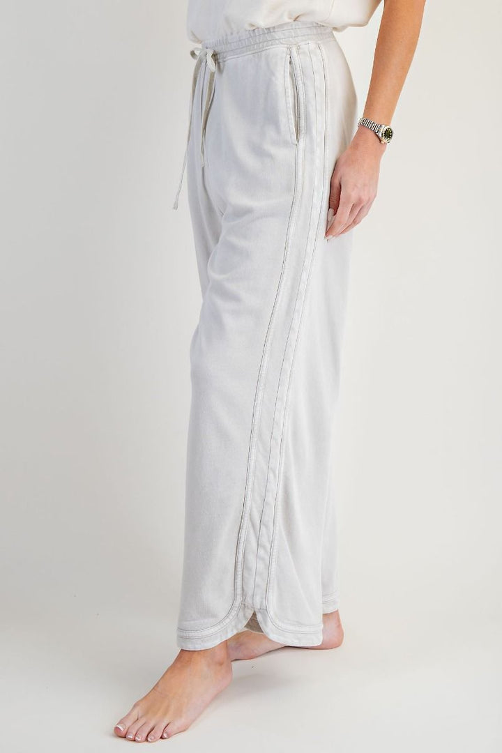 Light gray pants worn by a person on a white background