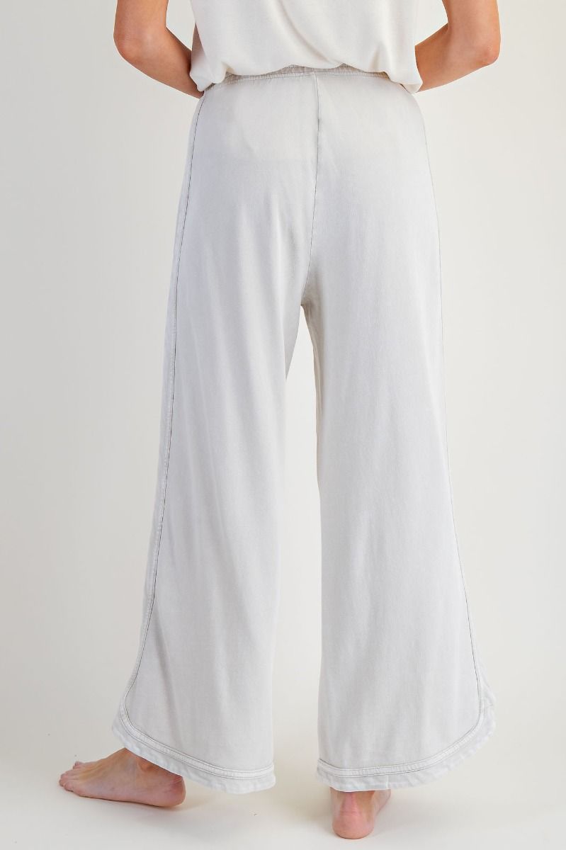 Person wearing white wide-leg pants on a plain background