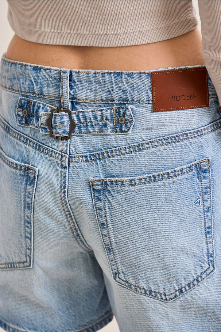 Close up of cinch buckle on back of denim shorts