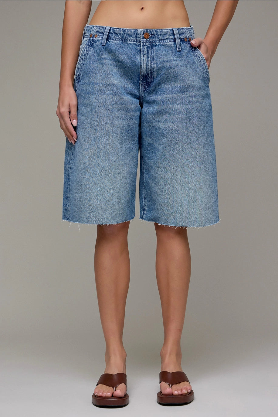 Person wearing blue denim shorts on a plain background