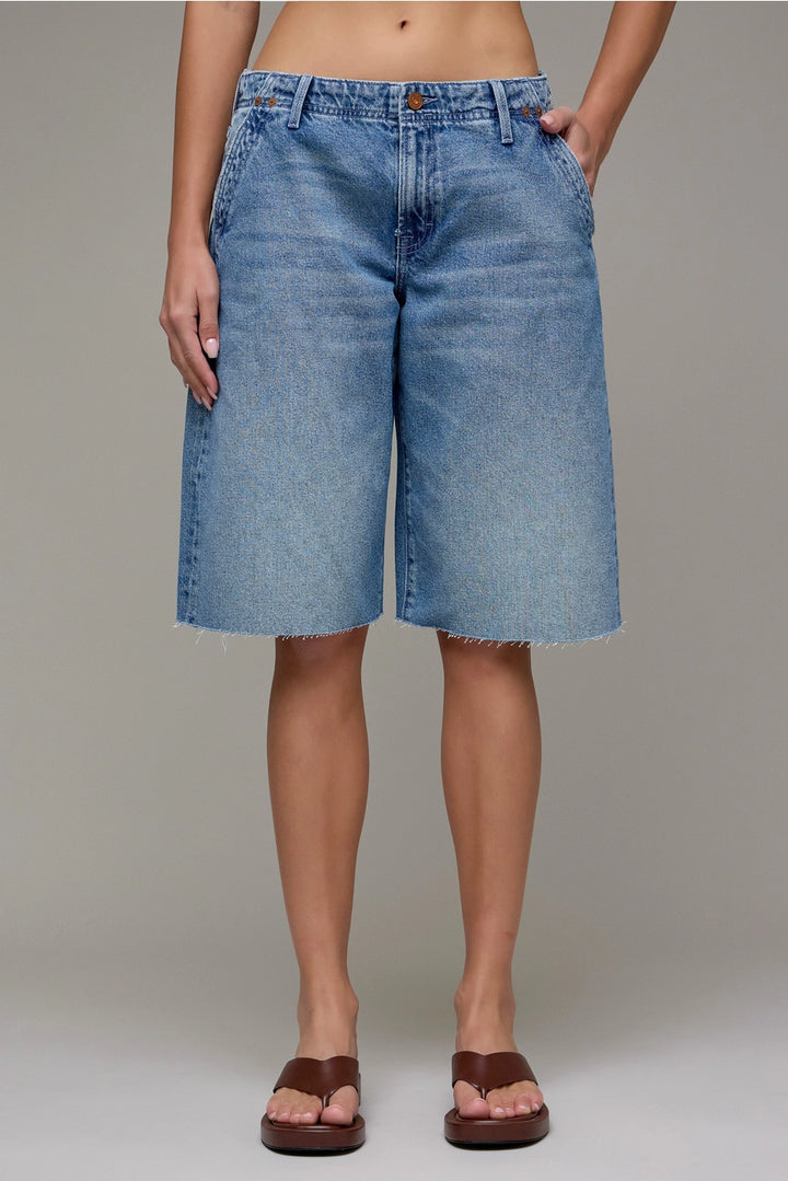 Person wearing blue denim shorts on a plain background