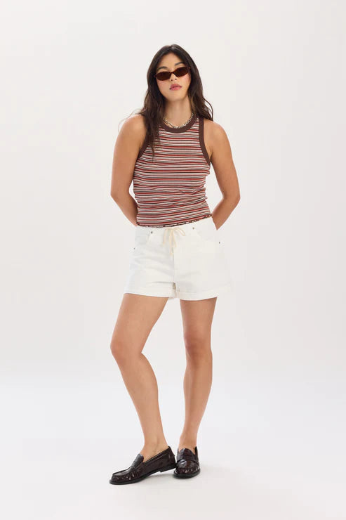 Woman wearing a striped tank top and white shorts on a white background