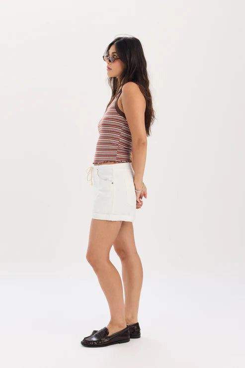 Woman wearing a striped tank top and white shorts on a white background