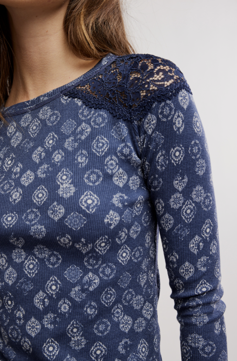 Woman wearing blue patterned top on white background