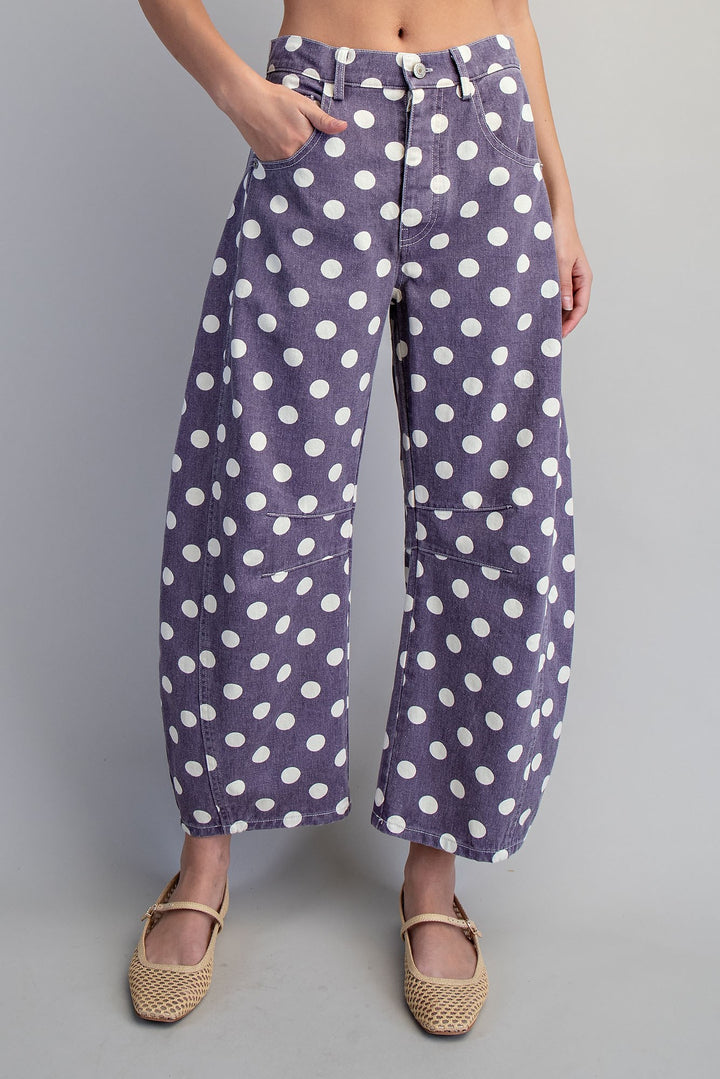 Woman wearing purple and white polka dot pants on plain background