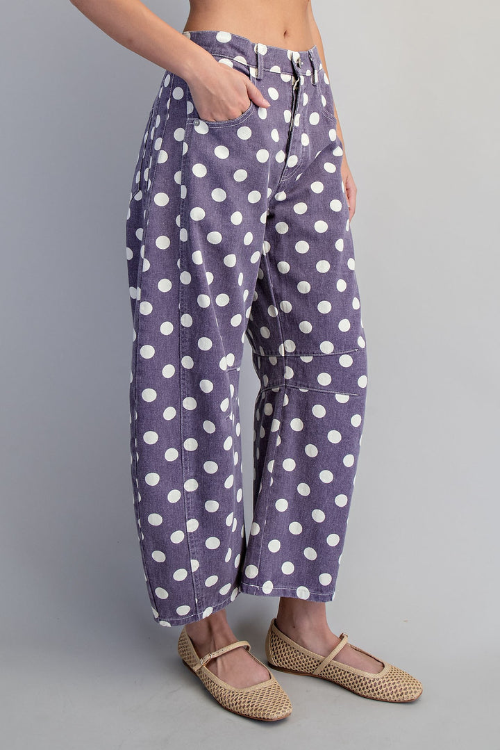 Woman wearing purple and white polka dot pants on plain background
