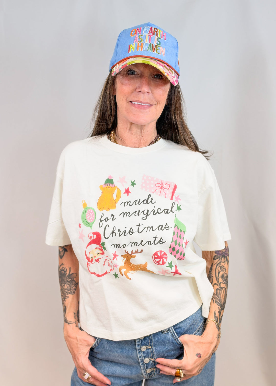 Woman wearing graphic tee including christmas items on plain background