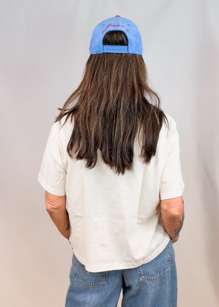Woman shown from back wearing tee on plain background