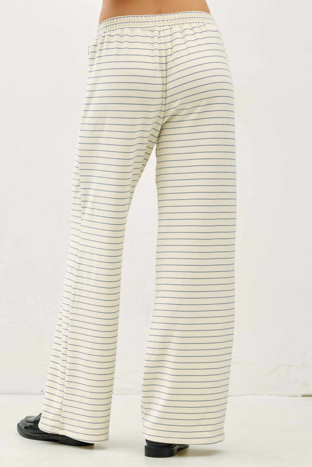 Striped pants worn by a person on a white background