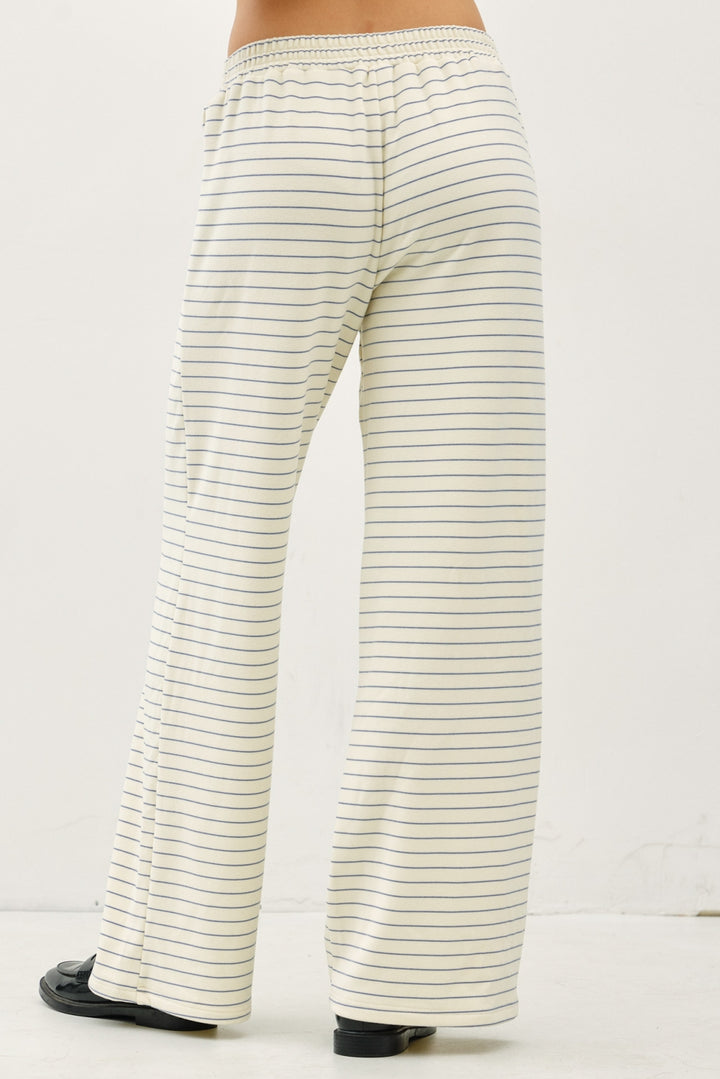 Striped pants worn by a person on a white background