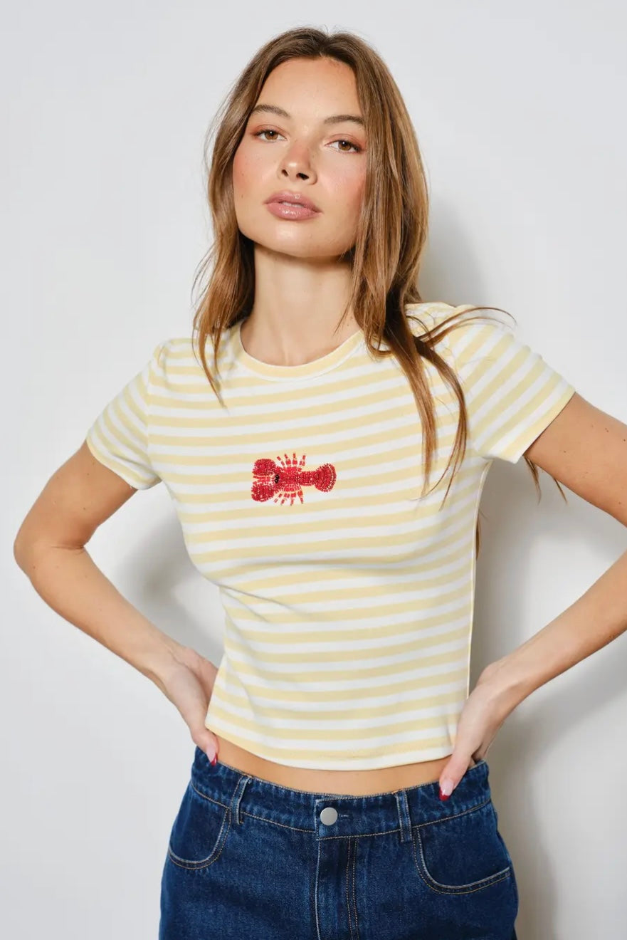 Woman wearing a yellow striped t-shirt with a red logo against a plain background