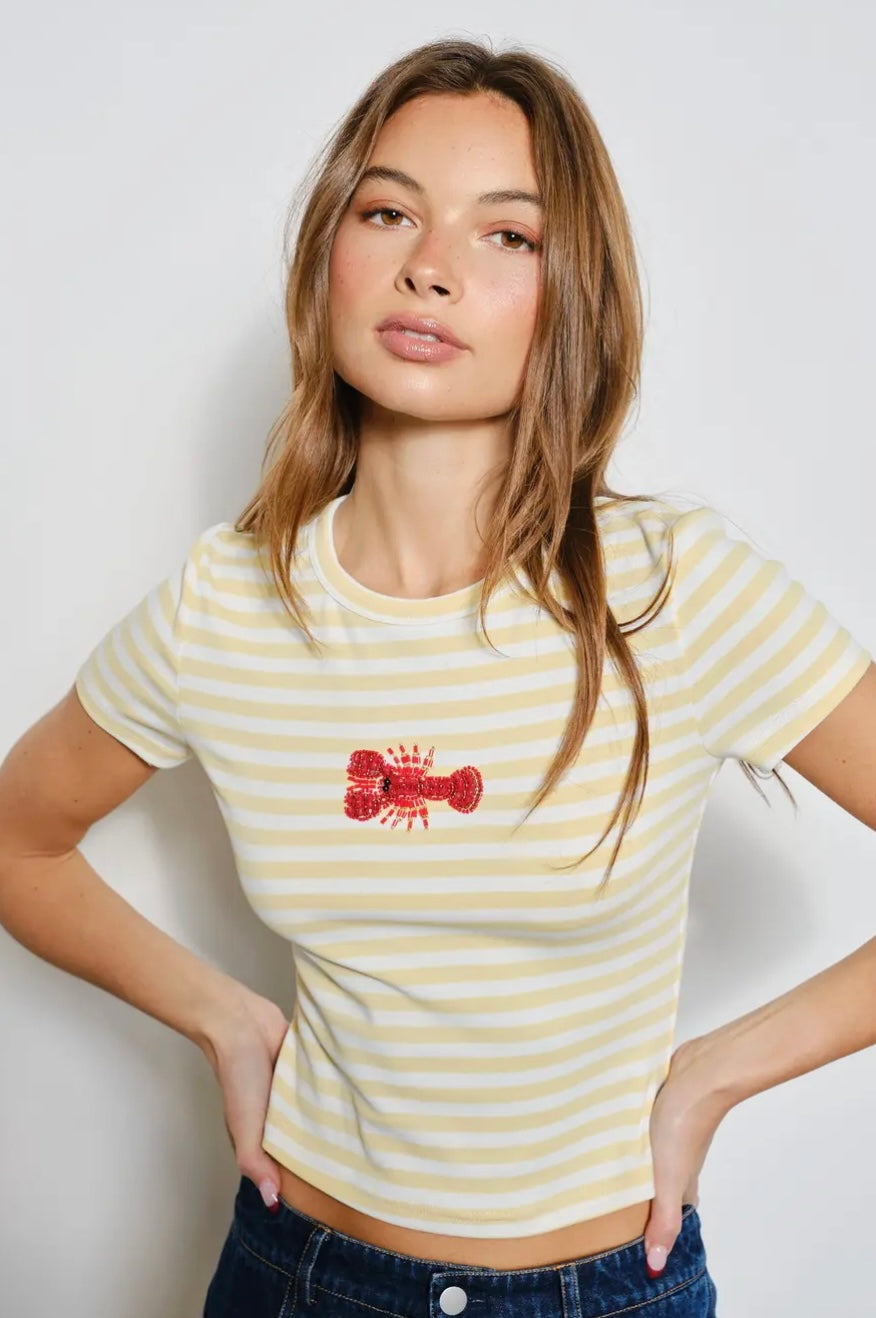 Woman wearing a yellow and white striped t-shirt with a red logo against a plain background