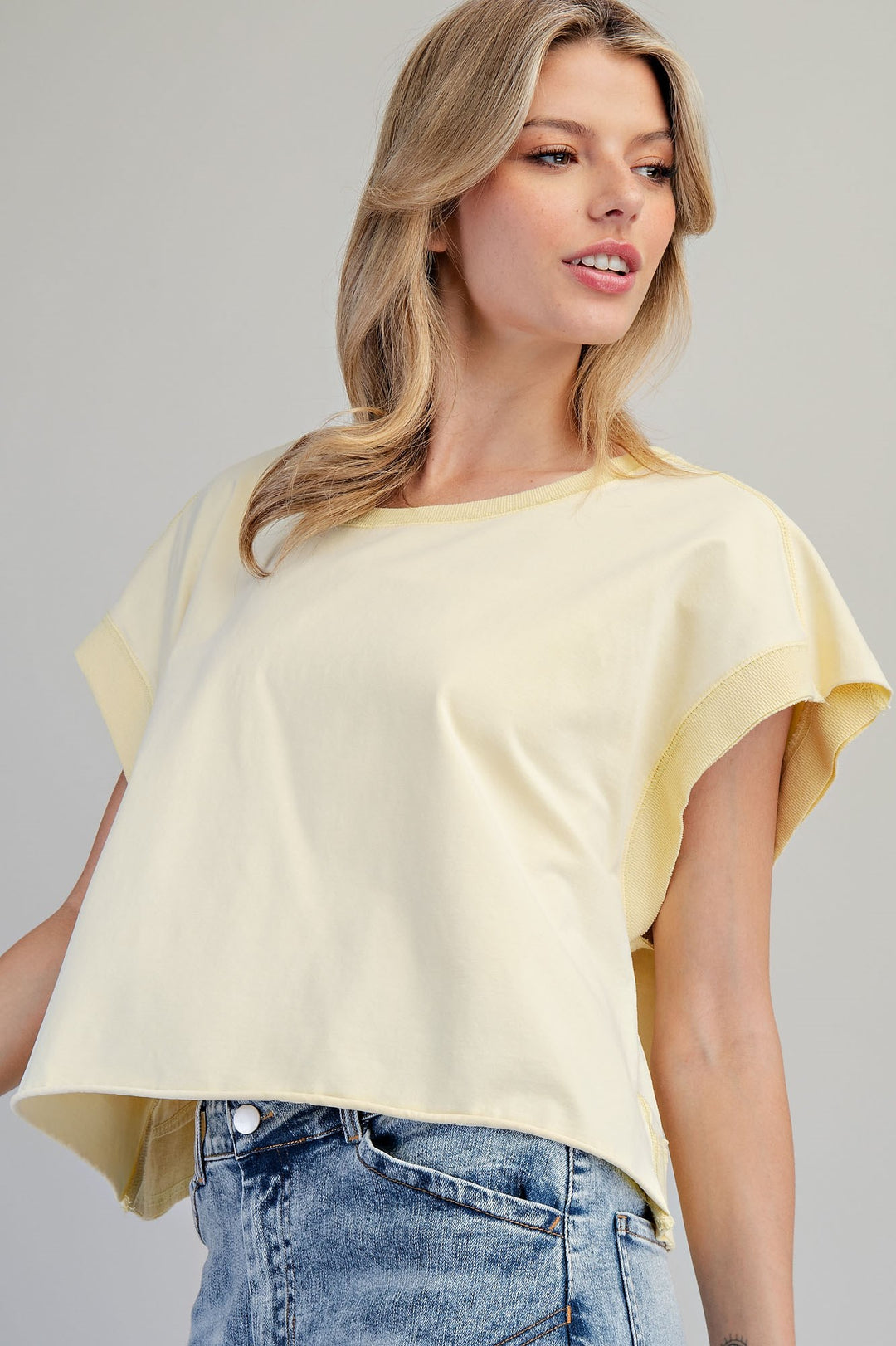 Woman wearing yellow tshirt on plain background