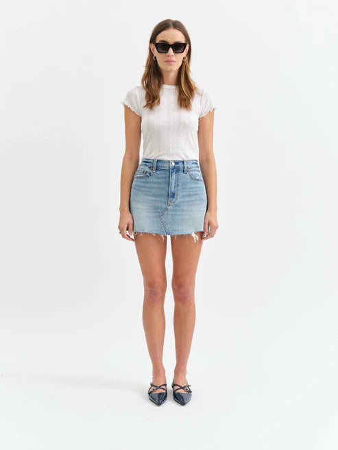 Woman wearing a white t-shirt and denim skirt on a white background