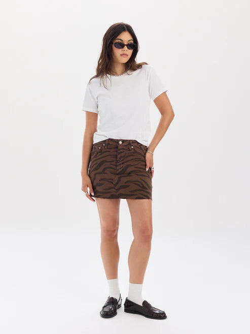 Woman wearing a white t-shirt and brown zebra-striped skirt on a white background