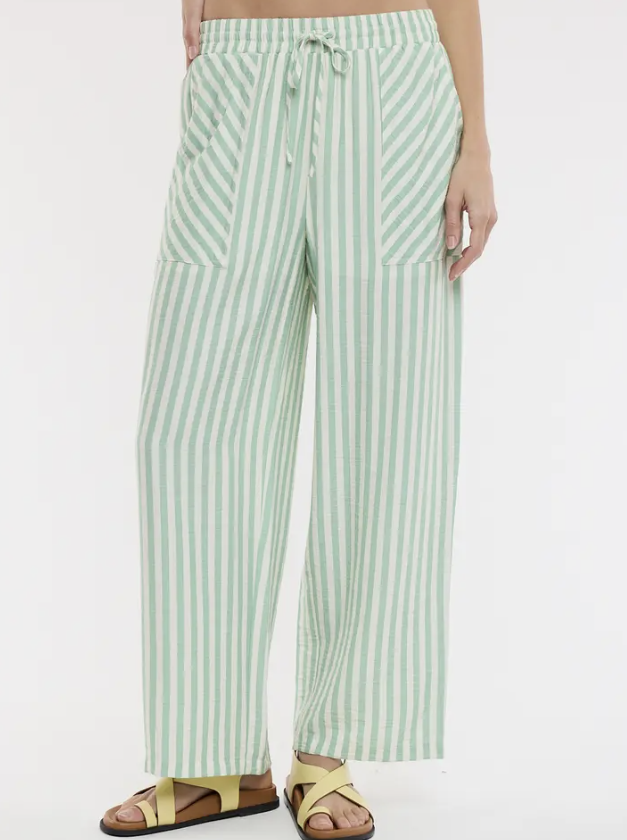 Green and white striped pants worn by a person on a light gray background