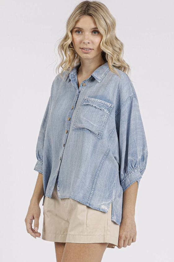 Woman wearing a light blue denim shirt on a white background