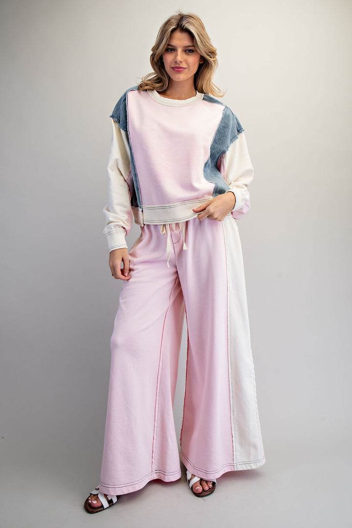 Woman wearing pink and denim matching set on plain background