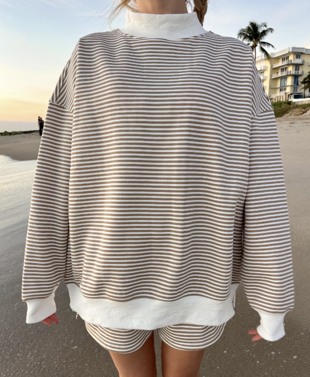 Woman wearing brown and white stripe pullover on the beach