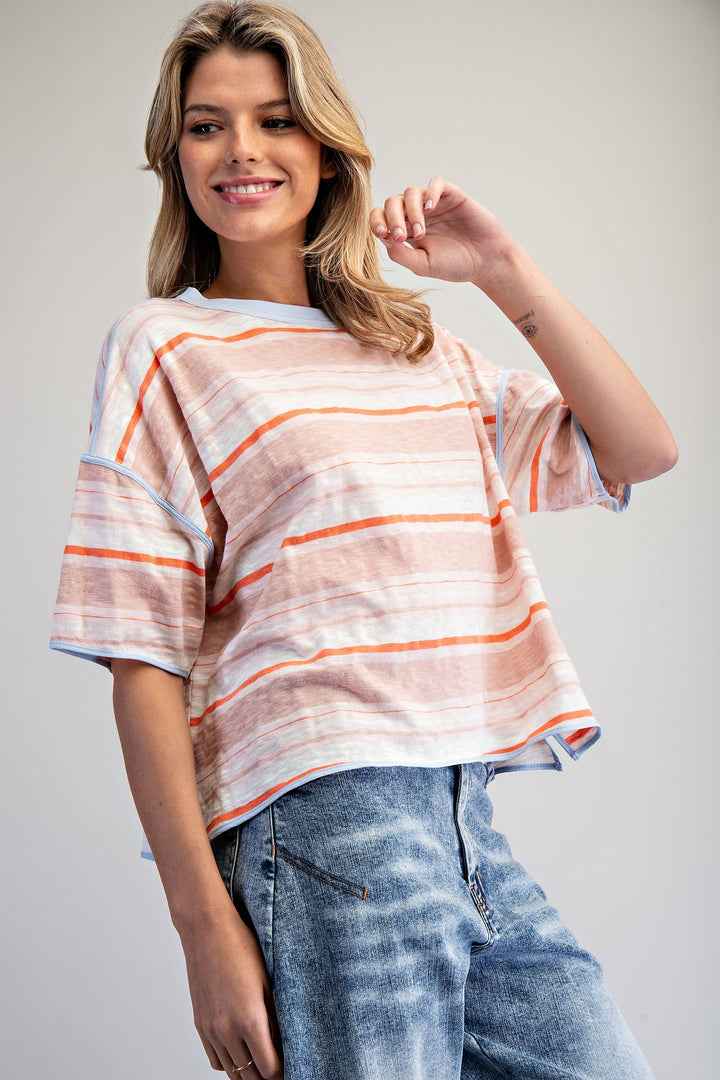 Woman wearing a striped shirt and jeans on a plain background