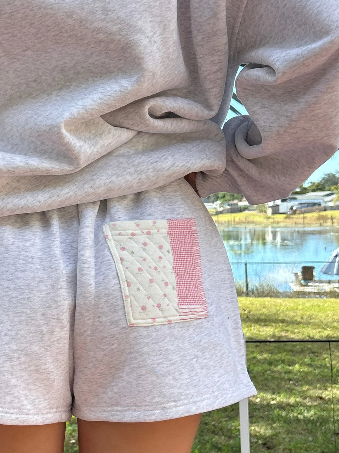 Person wearing grey shorts with patchwork pocket outdoors