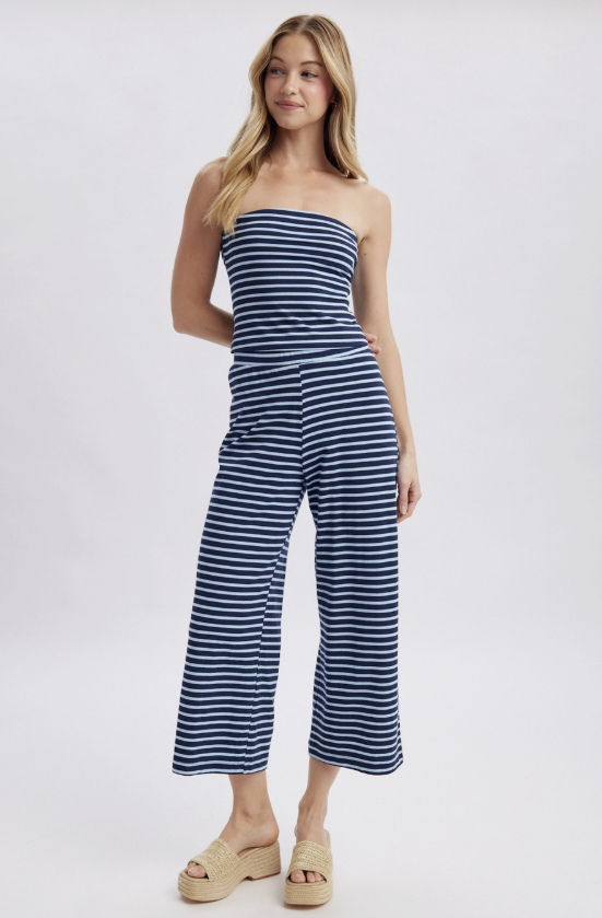 Woman wearing a blue and white striped strapless jumpsuit on a white background