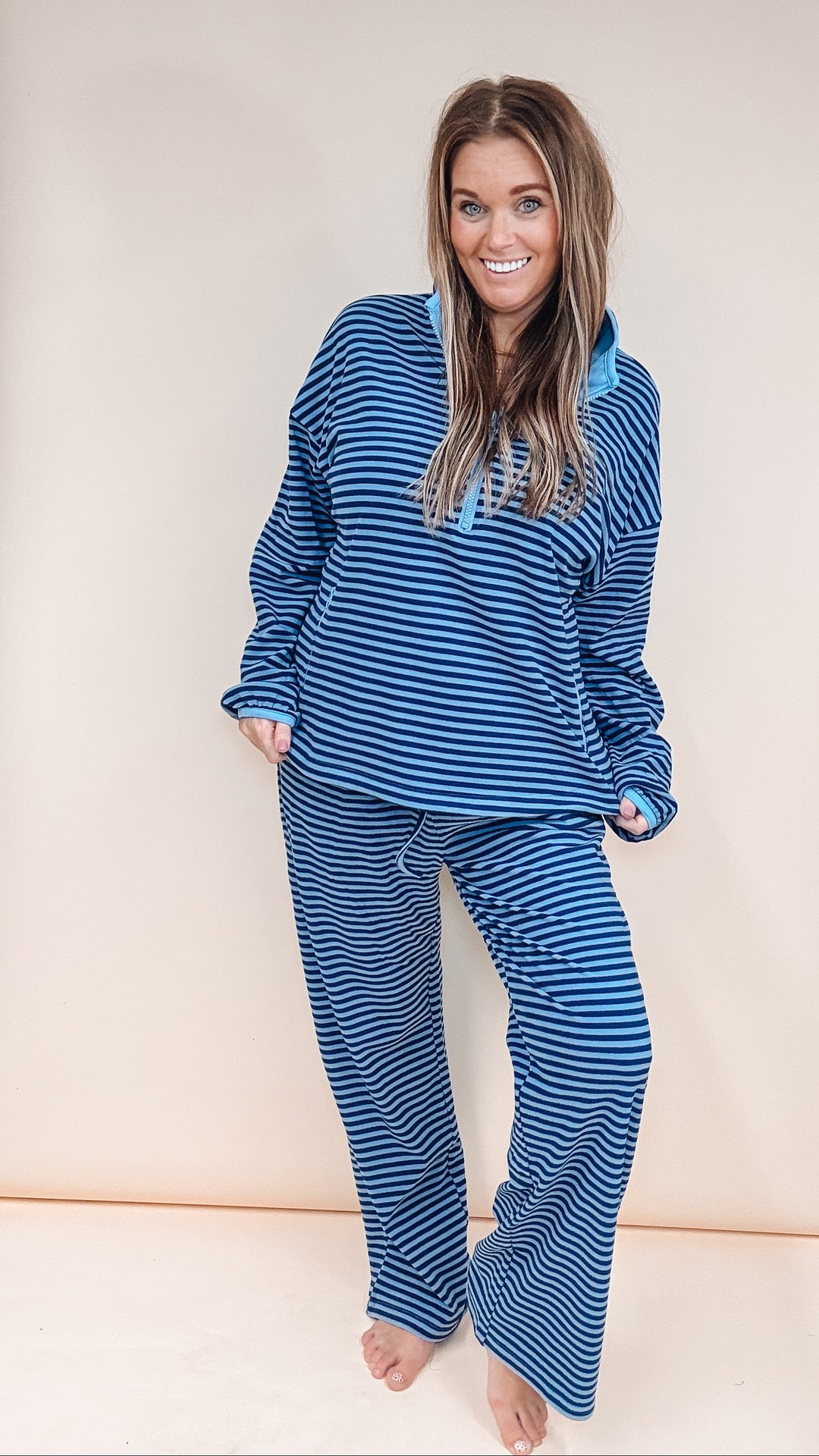 Woman wearing matching stripe set on plain background